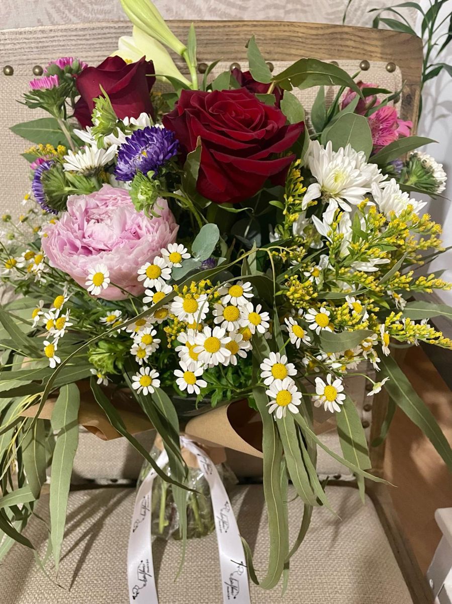 Ramo de rosa roja, peonía rosa y margaritas con eucalipto y cinta con el logo de MirFlores