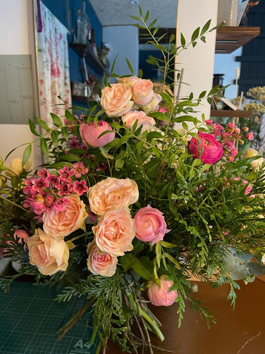 Arreglo de rosas melocotón y verdes en el taller de MirFlores