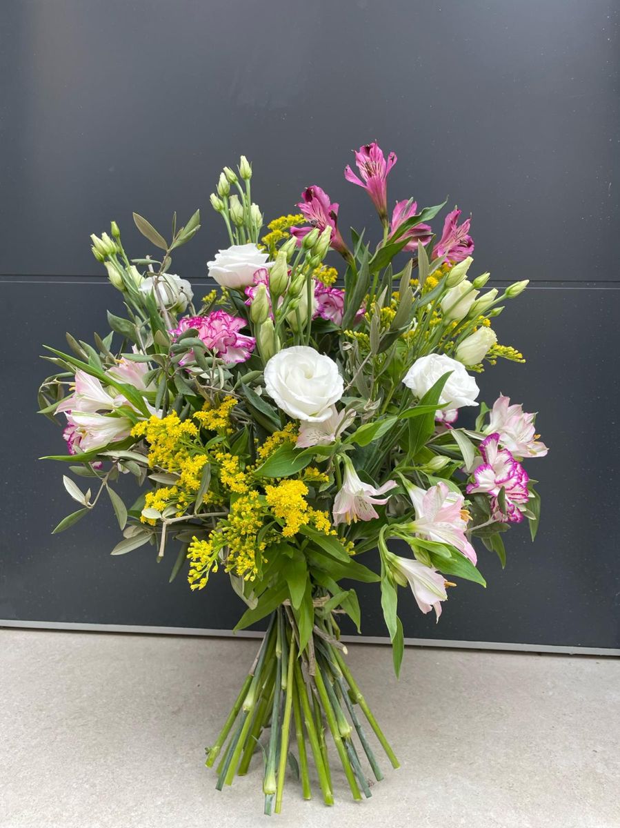 Ramo de lisianthus blancos, alstroemeria rosa y solidago sobre fondo gris